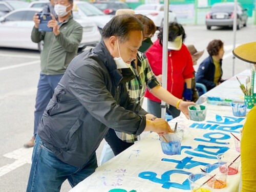 폐현수막을 재활용한 '현수막 수제작' 행사에서 정동균 군수가 자신의 이름을 적고 있다.