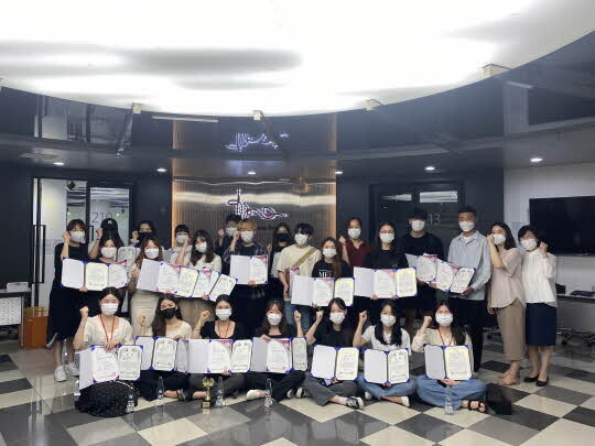 대구보건대학교 뷰티코디네이션과 학과 실습실 앞에서 대회에 수상한 학생들과 교수들이 상장을 들고 기념촬영을 하고 있다. <대구보건대학교 제공>