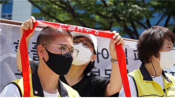 부산지역 마트 노동자들이 대형마트 구조조정을 막기 위해 6월 19일 오전 11시 부산시청에서 대회를 갖는 모습.
