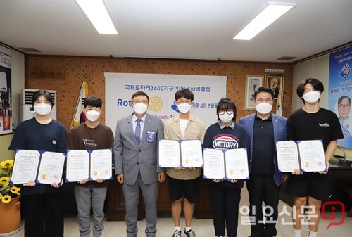 양평로타리클럽 임관수 회장과 관명인 유영희 전 회장이 장학증서를 수여하고 학생들과 기념촬영을 하고 있다.