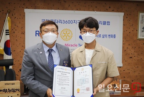임관수 회장이 한성대학교 4학년 장동화 학생에게 장학증서를 수여하고 기념촬영을 하고 있다.
