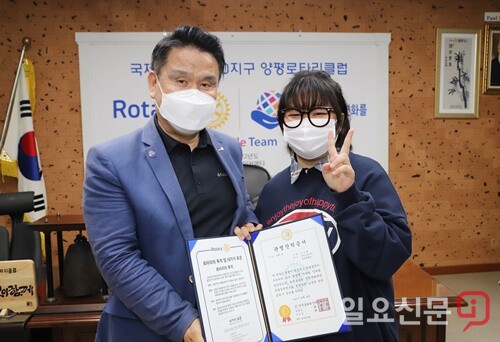 관명인 유영희 전 회장이 한샘고 1학년 이송현 학생에게 장학증서를 수여하고 기념촬영을 하고 있다.