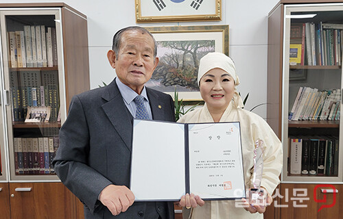 양평문화원 최영식 원장이 양평민요보존회 신필호 회장에게 제23회 경기도민속예술제 '예술상'을 전수하고 있다.