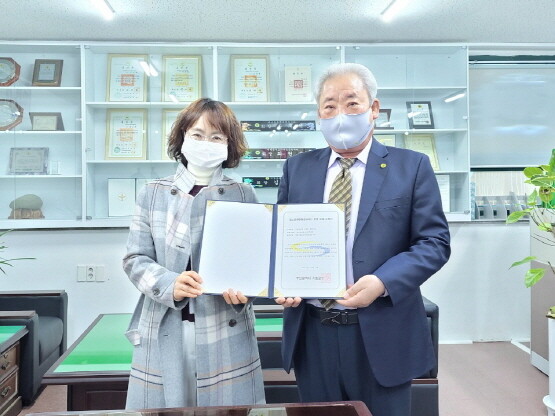 새마을운동 기장군지회 송후석 지회장(오른쪽)에게 청소년유해환경감시단 지정서를 전달하는 모습.