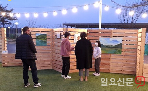 엄마 손을 잡고 전시회를 찾은 어린 소녀에게 김은영 작가가 작품을 설명하고 있다