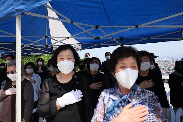 '아버지, 저희 알아보시겠죠?' 바람에 흔들리는 태극기를 바라보며 가슴에 손을 얹고 나라에 대한 충성을 맹세하는 6·25유자녀들. 눈시울을 붉히고 있는 딸들. 사진=남경원 기자