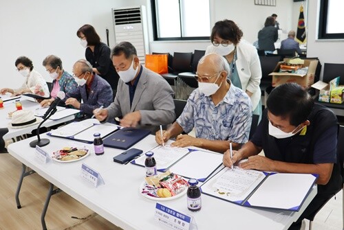 협약서에 서명하는 한현수 양평농협 조합장과 관내 경로당 5개소 회장. 사진=양평군노인회 제공.