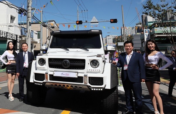 이종화 대구경제부시장과 류규하 대구중구청이 '벤츠G63AMG' 앞에서 레이싱모델과 함께 기념촬영을 하고 있다. 24일 오전 11시께 대구 남산동 자동차부속골목에서 '2022 대구스트리트모터페스티벌(DSMF2022)'이 열린 현장. 사진=남경원 기자
