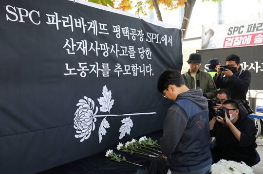 20일 오후 서울 양재동 SPC 본사 앞에서 열린 '평택 SPC 계열사 SPL 평택공장 산재사망 희생자 서울 추모' 행사에서 참가자들이 헌화하고 있다. 사진=박정훈 기자