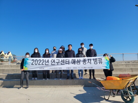 수산자원연구센터 직원들과 어촌계 주민들이 해삼종자를 방류하고 기념사진을 촬영하고 있다. 사진=기장군 제공