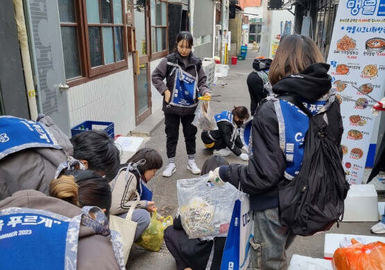 대선주조 임직원들과 ‘쓰줍인’ 회원들이 4일 오후 부산 서면 상권을 청소하는 모습. 사진=대선주조 제공