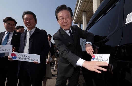 이재명 더불어민주당 대표가 22일 국회 본청 앞에서 열린 대일굴종외교 규탄 태극기달기 운동 행사에서 '역사를 팔아서 미래를 살 수는 없습니다' 문구가 담긴 태극기 스티커를 차량에 붙이고 있다. 사진=박은숙 기자
