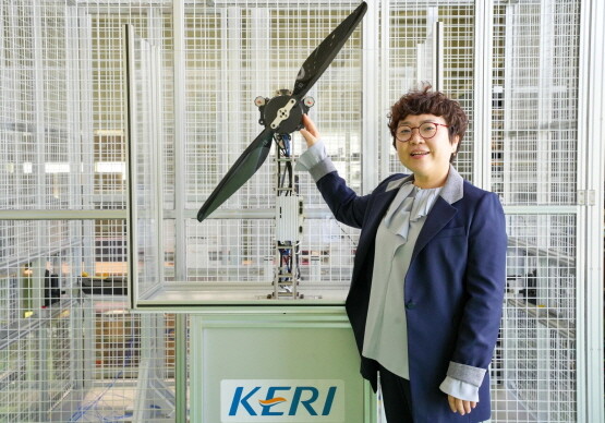 KERI 이지영 항공모빌리티추진연구팀장이 항공 모빌리티용 프로펠러 및 모터 앞에서 포즈를 취하고 있다. 사진=한국전기연구원 제공