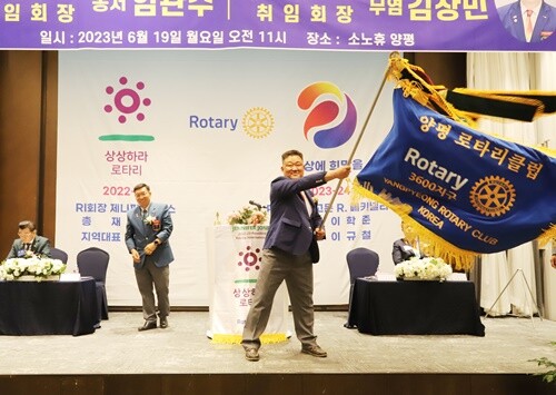 양평로타리클럽 신임 회장으로 취임한 무염 김창민 신임 회장이 클럽기를 전달받아 힘차게 흔들고 있다. 사진=김현술 기자