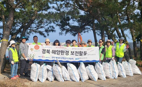 경북해양환경해설사연합회 회원들이 영덕 동해안 일원에서 해양환경정화 봉사 활동을 깆고 기념촬영을 하고 있다. 사진=박상욱 기자