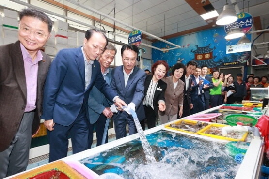 박동식 사천시장과 윤형근 시의장 등이 21일 삼천포용궁수산시장에서 해수공급시설 준공식을 가진 뒤 시장 수조에 직접 해수를 공급하고 있다. 사진=사천시 제공