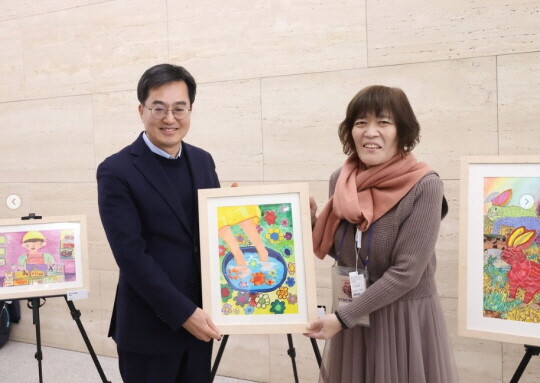 김동연 경기도지사가 발달장애인 이창옥 작가와 '맛사지사'라는 그림을 함께 들고 있다.