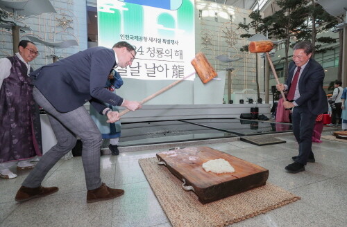 8일 인천공항 제1여객터미널 중앙 밀레니엄홀에서 진행된 설 명절 특별행사에서 인천국제공항공사 이학재 사장(사진 오른쪽)이 공사에서 파견근무 중인 스키폴공항 소속 Gijs Konink(하이스 코닉) 씨와 떡메치기 체험을 하고 있다. 사진=인천공항공사 제공