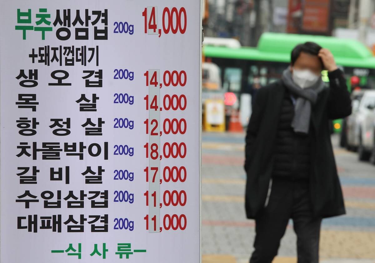 서울 시내 한 식당의 수정된 음식 가격표 앞으로 시민이 지나가고 있다. 사진=박정훈 기자