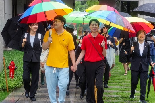 동성 연인 건강보험 피부양자 자격과 관련해 국민건강보험공단을 상대로 제기한 보험료 부과 처분 취소 소송에서 승소한 소성욱 씨(왼쪽)와 김용민 씨가 손을 잡고 밝은 표정으로 서울 서초구 대법원을 떠나고 있다. 사진=연합뉴스