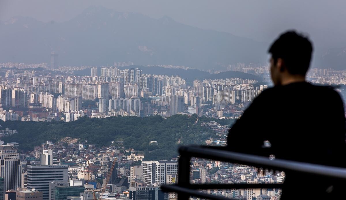 한 시민이 아파트 촌을 바라보고 있다. 사진=최준필 기자