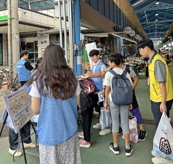 IPA 직원들이 저소득 가정 아동과 함께 전통시장에서 장을 보고 있다. 사진= 인천항만공사 제공