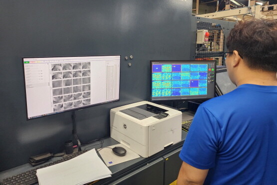 넥센타이어 직원들이 AI 제품 검사 자동화 플랫폼을 이용해 제품의 결함 유무를 판정하고 있다. 사진=넥센타이어 제공