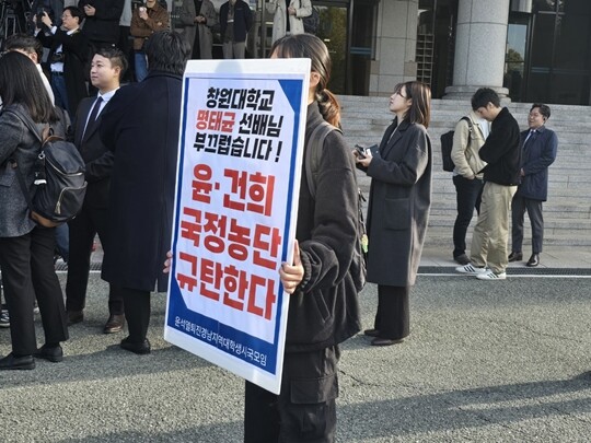 한 창원대학교 재학생이 명태균 씨와 윤석열 대통령 부부를 규탄하는 내용이 담긴 피캣을 들고 있다. 명 씨는 창원대학교를 졸업했다. 사진=이강원 기자