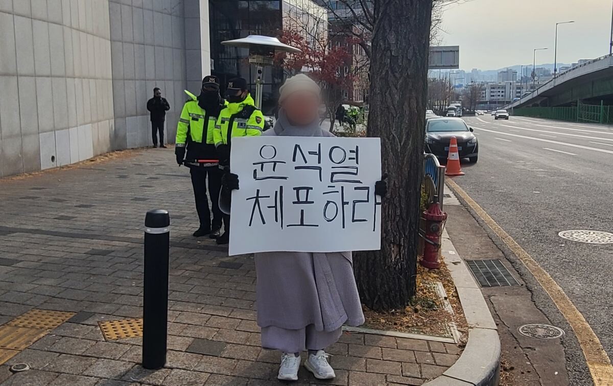 13일 서울 용산구 한남동 대통령 관저 주변에서 한 시민이 '윤석열 체포하라'고 적은 종이를 들고 1인 시위를 하고 있다. 사진=이강훈 기자