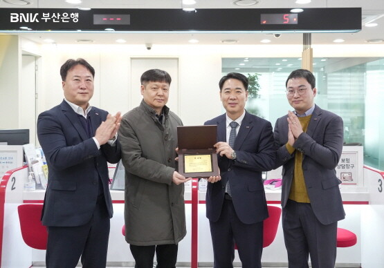 감사패 전달 장면. 오른쪽 두 번째부터 부산은행 김병기 경영지원그룹장, 박천규 씨. 사진=부산은행 제공