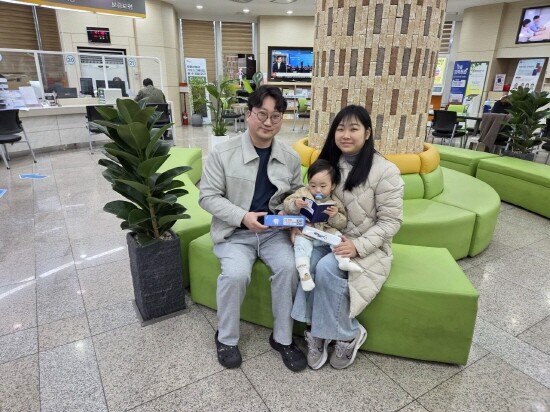 김해시에 거주하는 가족이 여권 홍보물 배부받은 후 기념촬영을 갖는 모습. 사진=김해시 제공