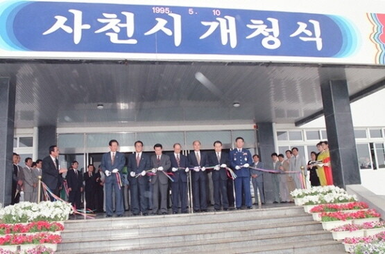 지난 1995년 5월 10일 통합 사천시 개청식이 열린 가운데 초대 한창일 시장을 비롯한 참석자들이 테이프 커팅을 하고 있다. 사진=사천시 제공