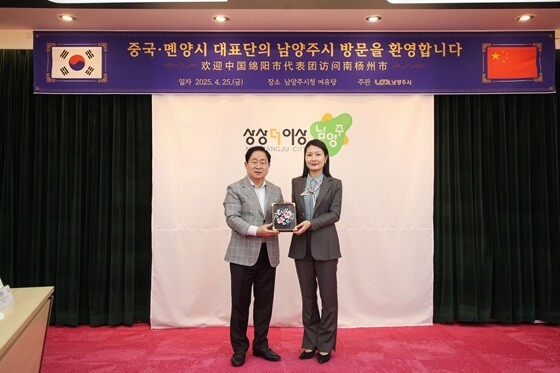 주광덕 남양주시장(왼쪽)이 남양주시를 방문한 중국 몐양시 대표단의 천충눠 상무국장에게 기념품을 전달하고 있다. 사진=남양주시 제공