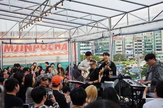 광안리 해변이 보이는 삼진포차에서 공연하고 있는 가수 장범준과 브래드. 사진=삼진어묵 제공