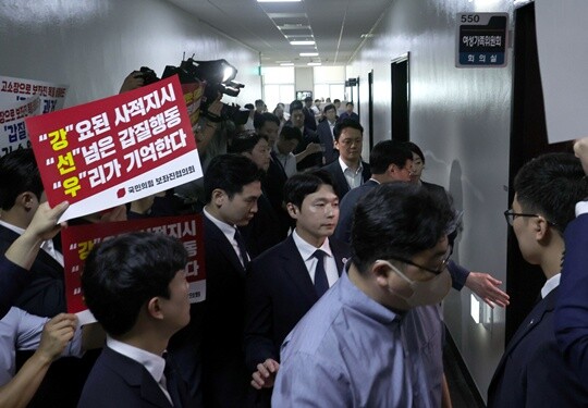 국민의힘 보좌관협의회 회원들이 피켓시위를 벌이자 강선우 여성가족부 장관 후보자가 보좌관들의 호위를 받으면서 7월 14일 국회 인사청문회장으로 입장하고 있다. 사진=이종현 기자