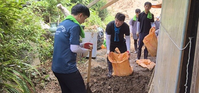 김종성 부의장과 최원중 의원이 산사테에 밀려온 토사를 퍼내고 있다. 사진=최남일 기자