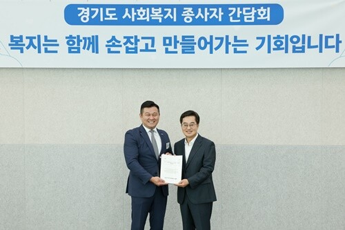 박찬수 회장(왼쪽)이 35,058명의 경기도 사회복지종사자 처우개선 서명지를 김 지사에게 전달했다. 사진=경기도청 제공