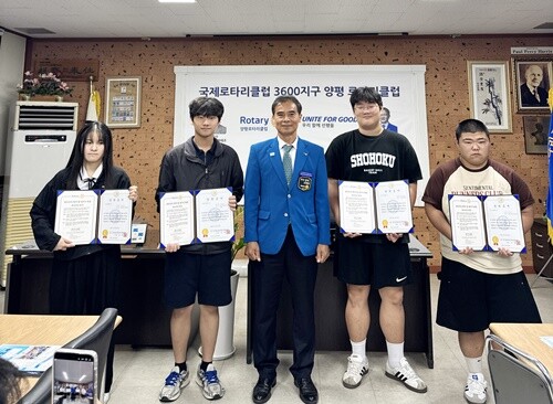 민재완 회장이 클럽 장학생 4명에게 장학증서와 장학금을 전달하며 환한 미소로 기념촬영을 하고 있다. 사진=양평로타리클럽 제공