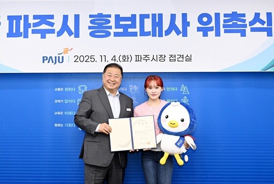 김경일 파주시장(왼쪽)이 로트 가수 김다현 씨에게 홍보대사 위촉장을 전달한 뒤 기념촬영을 하고 있다. 사진=파주시 제공