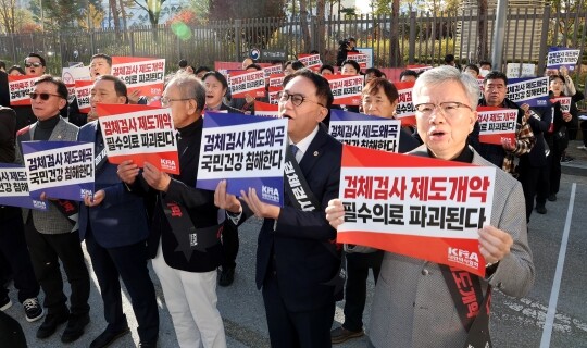김택우 대한의사협회 회장(오른쪽)을 비롯한 의사들이 11월 11일 오후 정부세종청사 보건복지부 앞에서 열린 '검체검사 제도개편 강제화 전면 중단 촉구 대표자 궐기대회'에서 구호를 외치고 있는 모습. 사진=연합뉴스