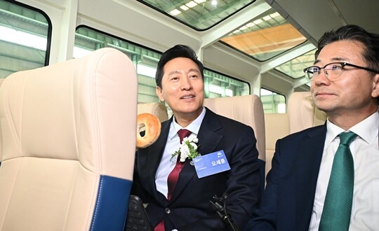 지난 2024년 11월 25일 경남 사천에서 ‘한강버스 안전기원 진수식’이 열린 가운데 오세훈 서울시장이 한강버스에 타 베이글을 들어보이고 있다. 사진=서울시 제공
