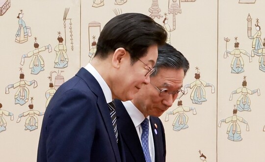 이재명 대통령이 7월 23일 서울 용산 대통령실 청사에서 열린 임명장 및 위촉장 수여식에서 정성호 법무부 장관과 기념촬영 뒤 자리를 옮기며 대화를 나누고 있다. 사진=연합뉴스
