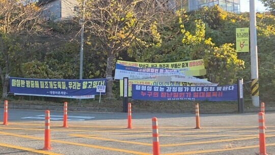 마을 초입에 공항 건설에 대한 각종 현수막이 설치된 모습. 일부 현수막에는 토지보상 상담을 홍보하는 세무업체와 법무법인 광고가 걸려 있기도 했다.  사진=최희주 기자