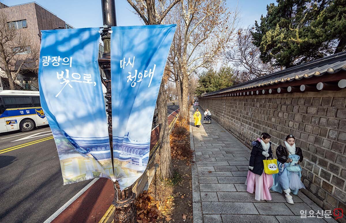 한복을 입은 관광객들이 청와대 앞 경복궁 돌담길을 걷고 있다.