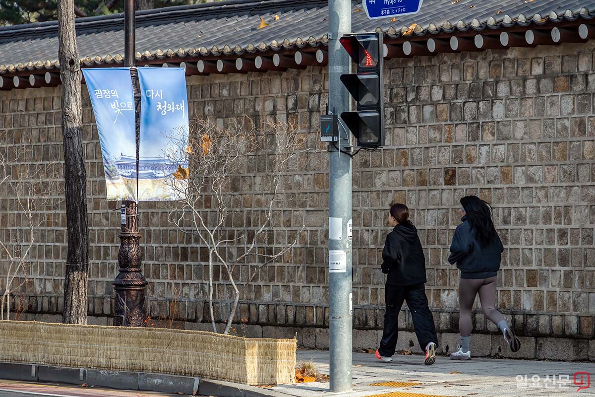 17일 청와대 인근 돌담길에서 조깅하는 주민들. '다시 청와대'라고 적힌 배너가 눈에 띈다.