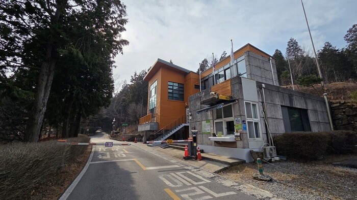국립남해편백자연휴양림 입구 도로에 불법 차단기와 건물이 설치된 모습. 사진=정민규 기자