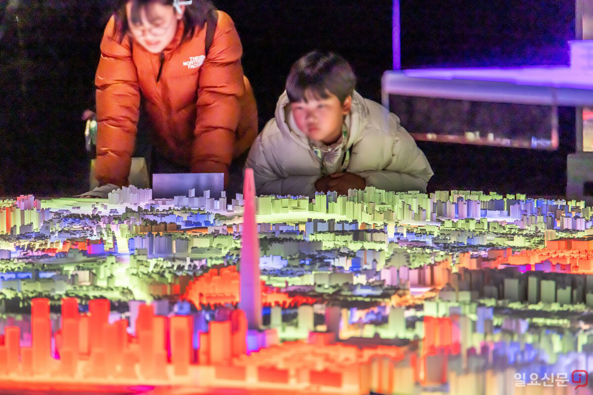 서울갤러리를 찾은 어린이 방문객들이 서울시 랜드마크 축소 모형을 자세히 들여다보고 있다.