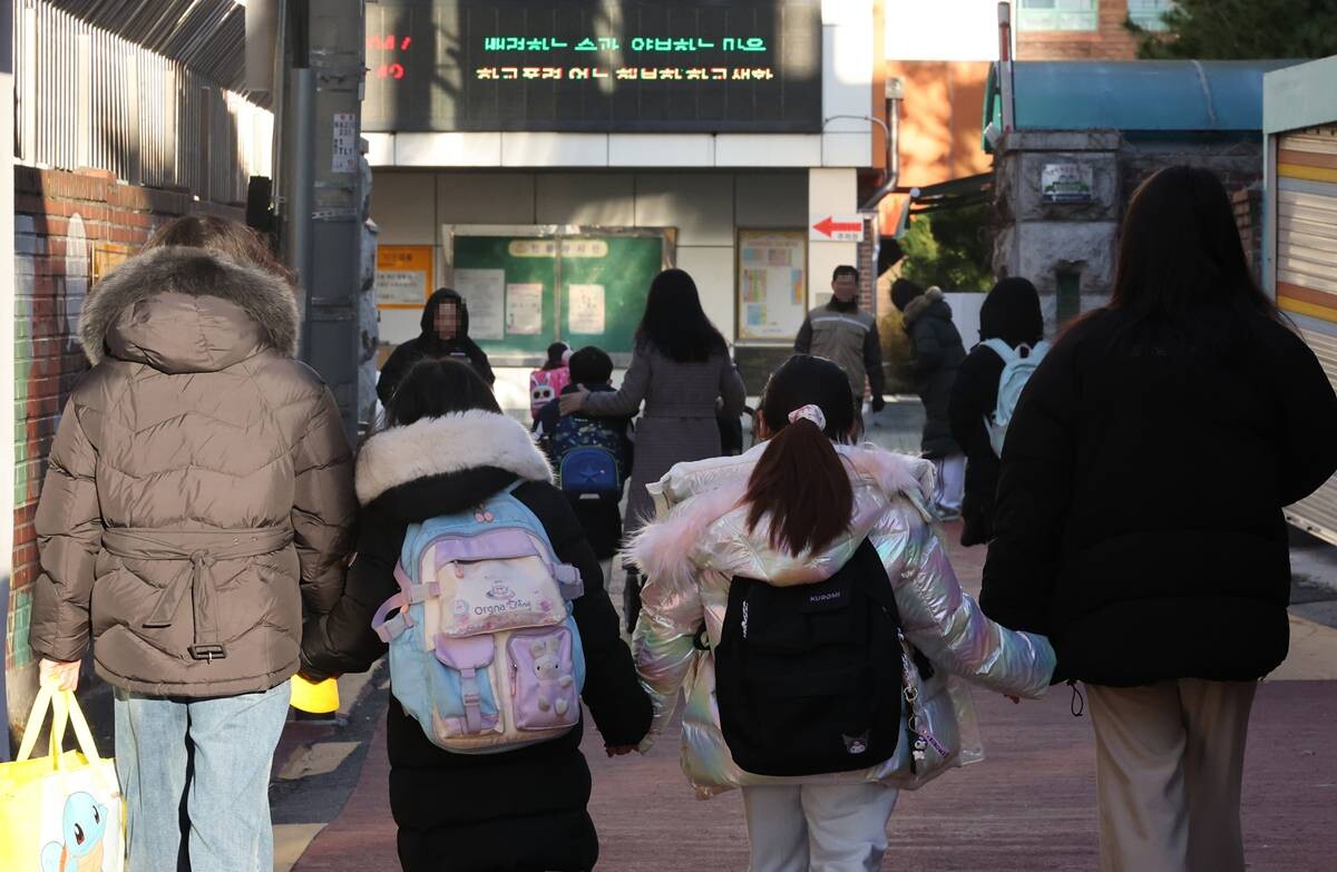 서울의 한 초등학교 인근에서 학부모들이 자녀의 손을 잡고 함께 교문으로 향하고 있는 모습. 기사의 특정 내용과 관련 없음. 사진=연합뉴스
