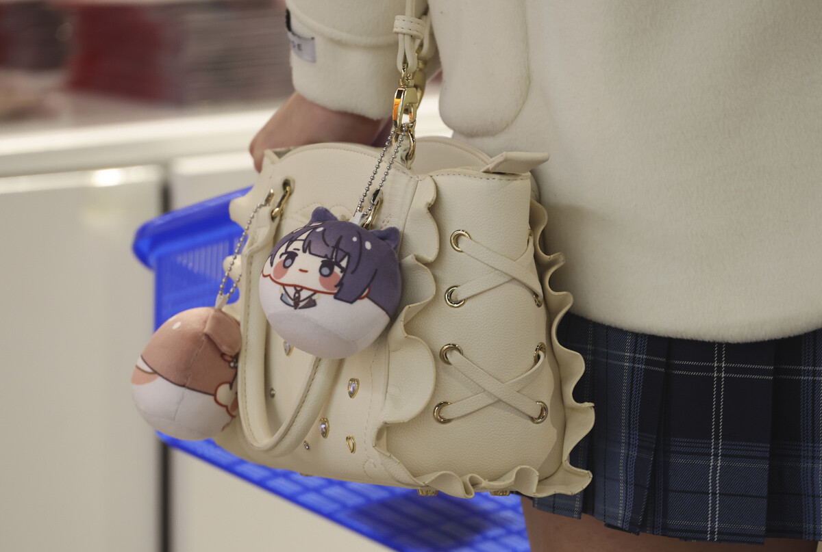 인기 캐릭터 키링을 가방에 단 고객이 팝업을 찾아 추가로 상품을 구매하고 있다.