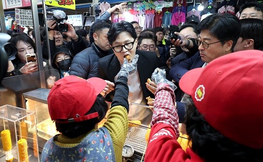 한동훈 국민의힘 전 대표가 2월 27일 오후 대구 서문시장에 도착해 상인들이 건네는 음식을 먹고 있다. 사진=연합뉴스